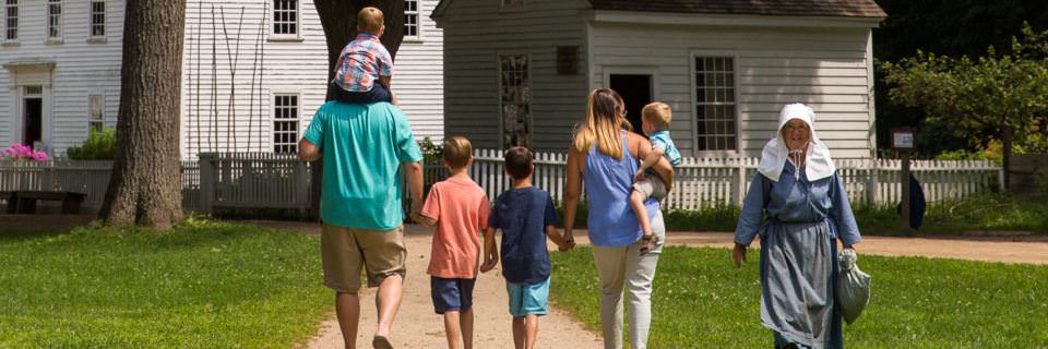 A family and a Costumed Historian cross paths on the Village Common