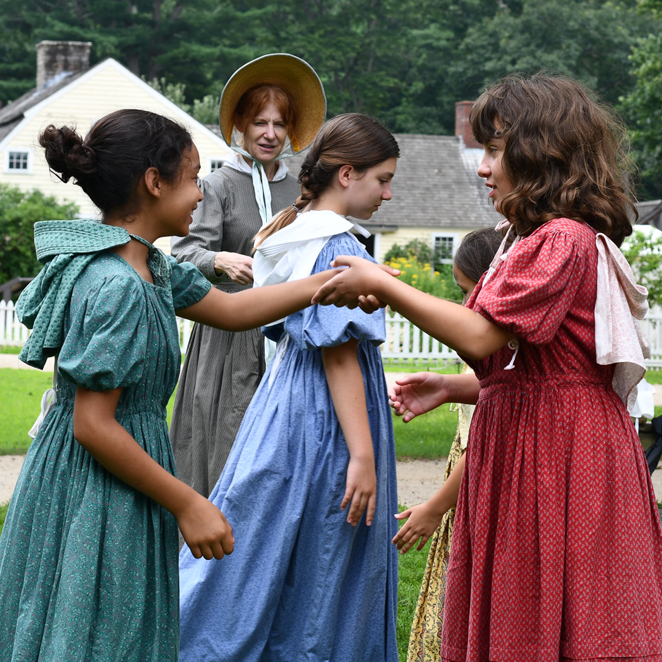 Group of costumed children dancing.