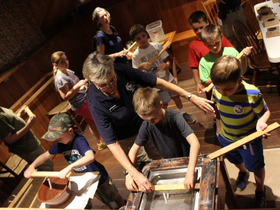 Students dip candles in the Museum Education Building