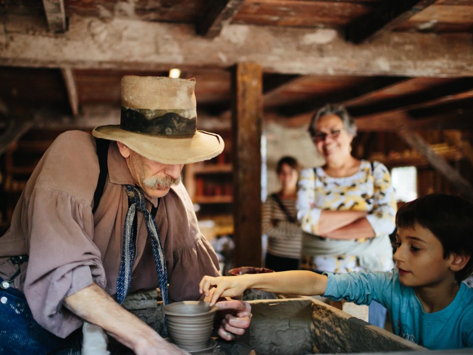 A school age boy watching the potter at work