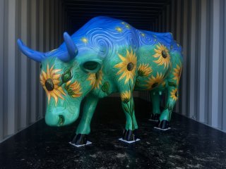 A life-size cow sculpture painted with sunflowers and starry skies