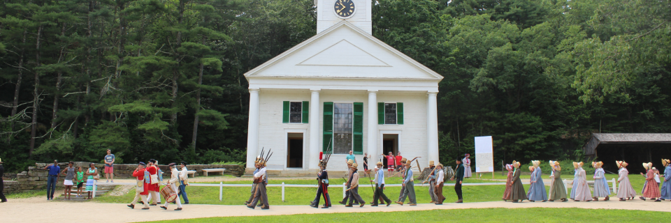 Costumed historians at the Village walk on parade
