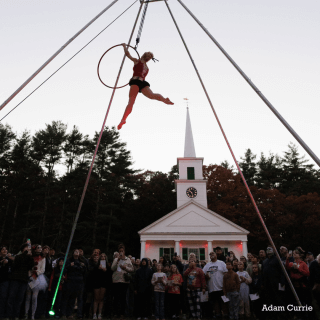 Acrobat in the air as people watch