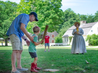 Visitors playing baseball on the Village Common lawn.